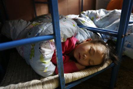 A girl sleeps in a dormitory at a kindergarten, a school for children of migrant workers, on the outskirts of Beijing November 8, 2013. REUTERS/Jason Lee