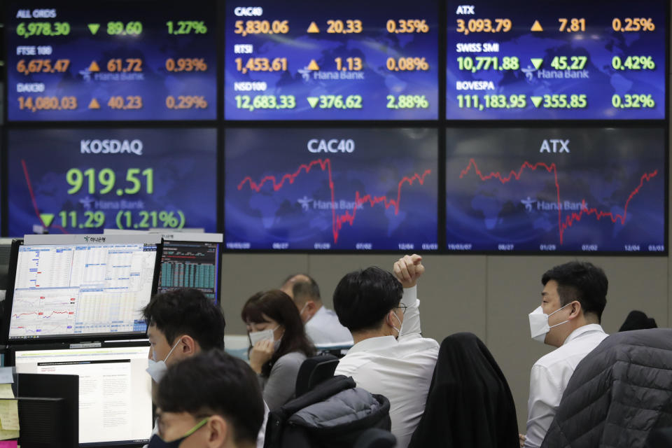 A currency trader talks with his colleague at the foreign exchange dealing room of the KEB Hana Bank headquarters in Seoul, South Korea, Thursday, March 4, 2021. Asian shares fell Thursday, tracking a decline on Wall Street as another rise in bond yields rattled investors who worry that higher inflation may prompt central banks to raise ultra-low interest rates. (AP Photo/Ahn Young-joon)