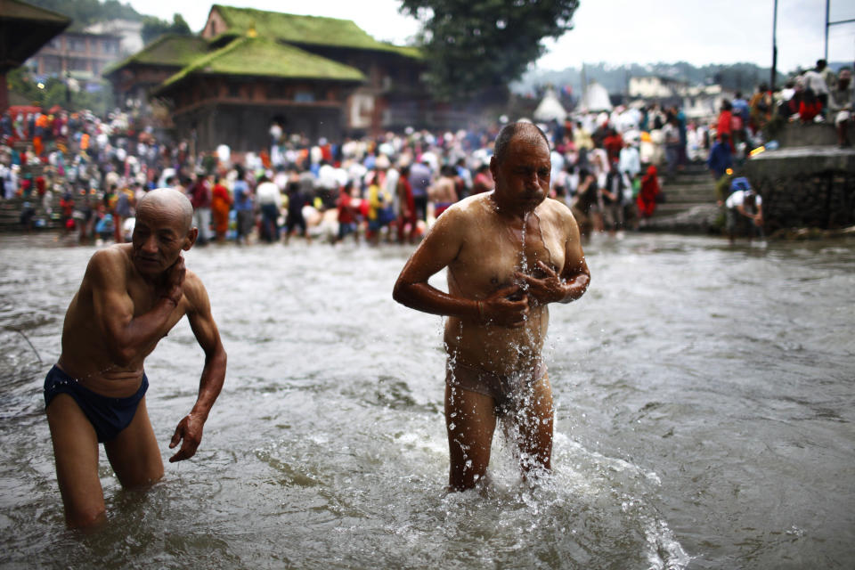 Nepalese Hindu people take holy bath during Kuse Aunsi or Nepalese Father's day at Gokarneshwar temple in Katmandu, Nepal, Friday Aug. 17, 2012. Kuse Aunsi is a unique Hindu festival of Nepal where fathers living or dead are honored. Children with living fathers show their appreciation by giving presents and sweets and those whose fathers are deceased pay tributes at Gokarneshwar temple. (AP Photo/Niranjan Shrestha)