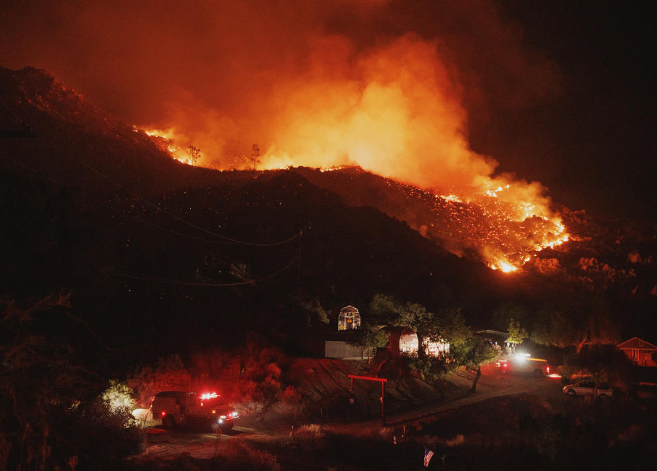 A hillside is illuminated by the Fairview Fire Monday, Sept. 5, 2022, near Hemet, Calif. (AP Photo/Ethan Swope)