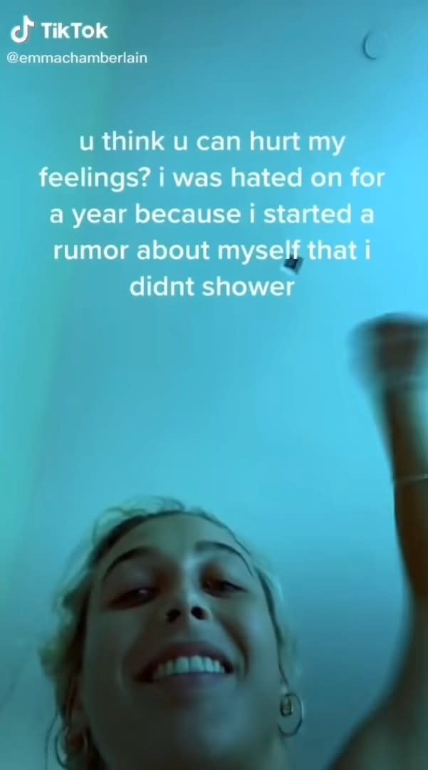 Emma smiling into the camera with text that says "u think u can hurt my feelings? i was hated on for a year because i started a rumor about myself that i didn't shower"