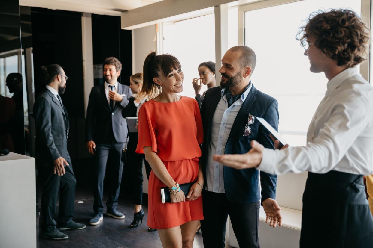 Wait staff of a luxury restaurant is welcoming business guests. Everyone is elegant to attend to an event.