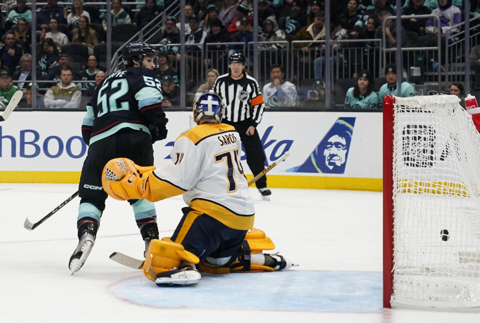 Seattle Kraken left wing Tye Kartye (52) watches as a goal by defenseman Brian Dumoulin makes it past Nashville Predators goaltender Juuse Saros (74) during the second period of an NHL hockey game Thursday, Nov. 2, 2023, in Seattle. (AP Photo/Lindsey Wasson)