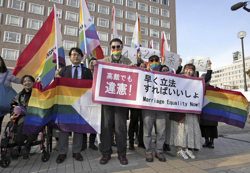 Plaintiffs and others shows a banner in front of Sapporo Hight Court in Sapporo, Hokkaido, northern Japan Thursday, March 14, 2024. A banner reads " Unconstitutional judgement by high court, too. Marriage Equality Now." The Sapporo High Court ruling said that not allowing same-sex couples to marry and enjoy the same benefits as straight couples violates their fundamental right to have a family. (Kyodo News via AP)