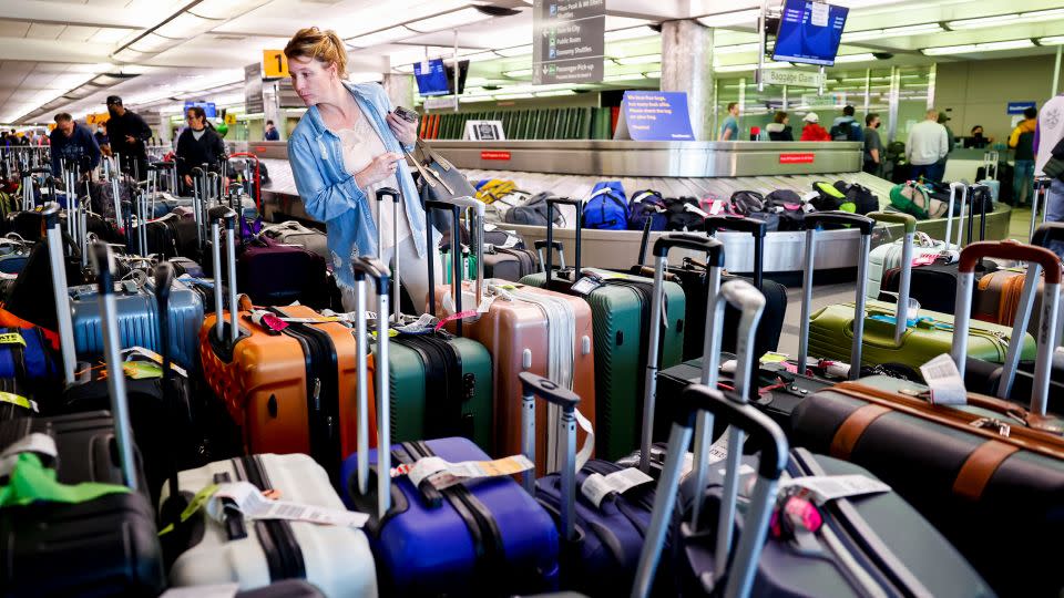 A traveler searches for a suitcase in a baggage holding area for Southwest Airlines at Denver International Airport on December 28, 2022. - Michael Ciaglo/Getty Images