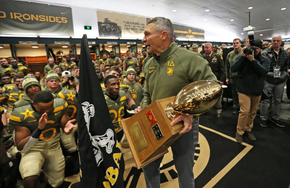 Army head coach Jeff Monken holds the winner's trophy after beating Navy in double overtime on Saturday in Philadelphia. DANNY WILD/USA TODAY Sports