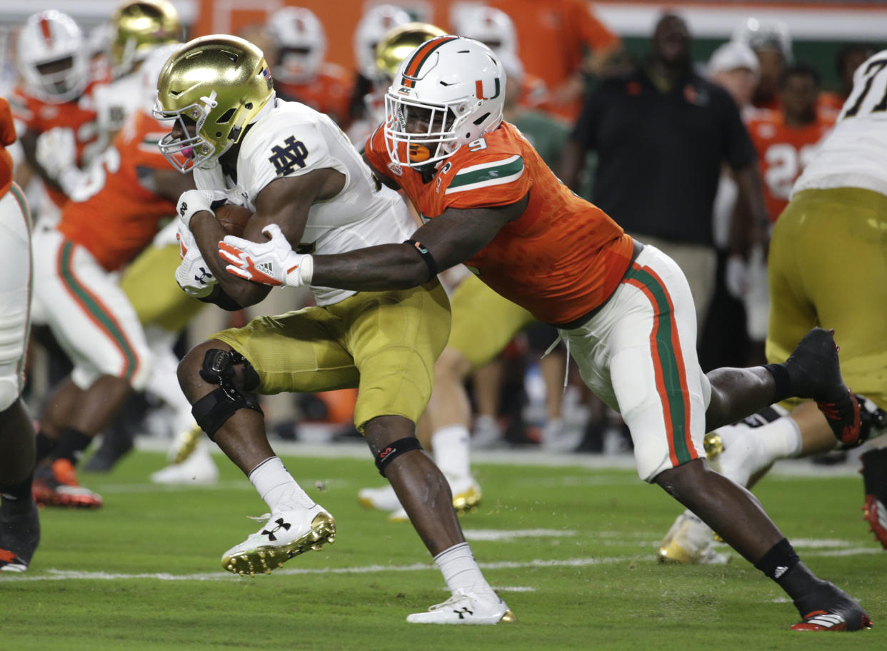 Notre Dame running back Josh Adams, left, is tackled by Miami defensive lineman Chad Thomas during the first half of an NCAA college football game, Saturday, Nov. 11, 2017, in Miami Gardens, Fla. (AP Photo/Lynne Sladky)