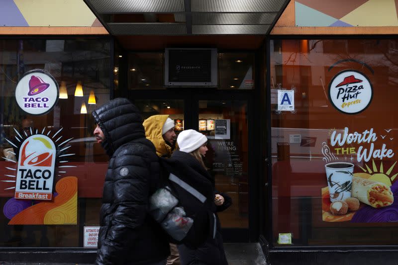FILE PHOTO: People walk by a Taco Bell and Pizza Hut, subsidiaries of Yum! Brands, Inc. in Manhattan, New York City