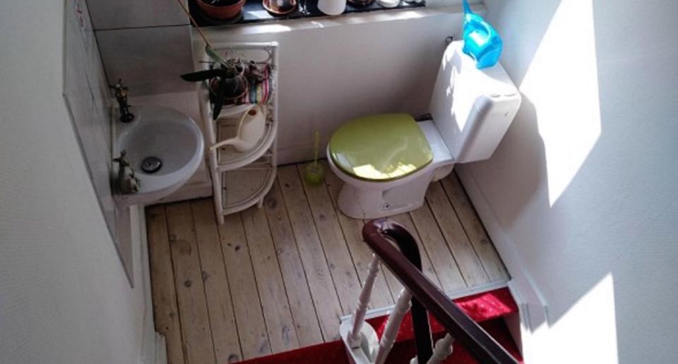 Baño en el descansillo de la escalera visto en un apartamento de AriBnb (Créditos: Redes Sociales)