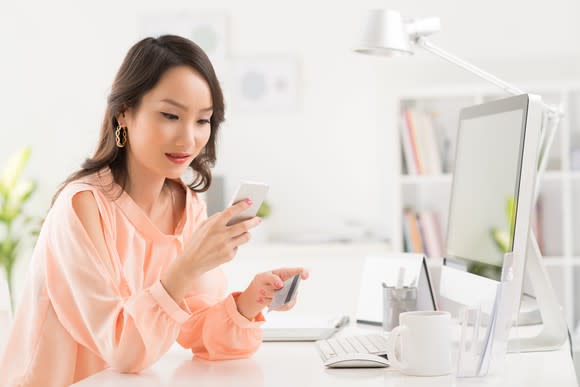 Asian woman shopping online with a credit card