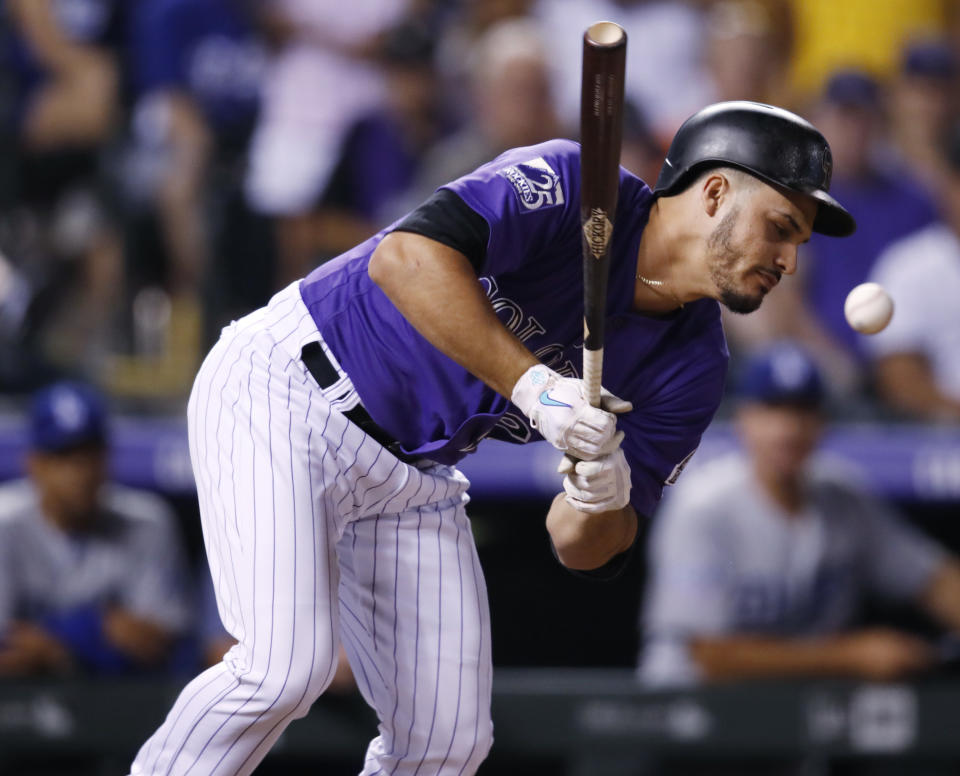 Colorado Rockies pinch-hitter Nolan Arenado reacts after beiing hit with a pitch thrown by Los Angeles Dodgers reliever JT Chargois in the ninth inning of a baseball game Saturday, Aug. 11, 2018, in Denver. (AP Photo/David Zalubowski)