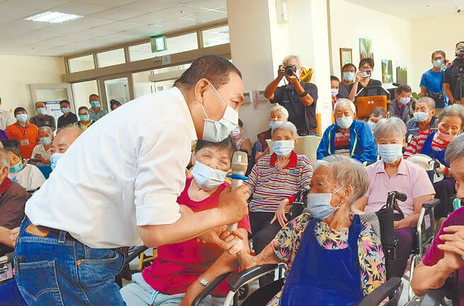 國民黨總統參選人侯友宜（左）13日參訪嘉義縣中埔鄉約翰樂活護理之家，緊握百歲人瑞阿嬤的手，互動熱絡，隨後發表長照政策。（廖素慧攝）