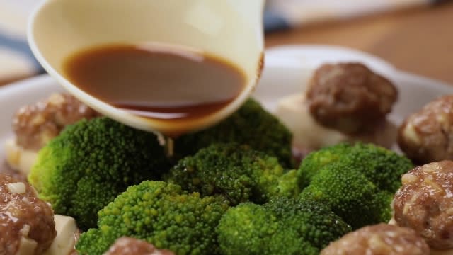 Spooing gravy over broccoli