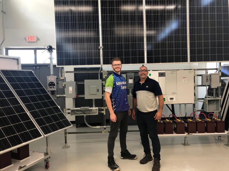 Devon Smith, left, a student at the Ramey Jobs Corps Center in Aguadilla, Puerto Rico, stands with Jose Gonzalez, his instructor. Gonzalez says solar energy development is a great opportunity for the island, providing good-paying jobs to young people while building power resiliency as climate change bears down.