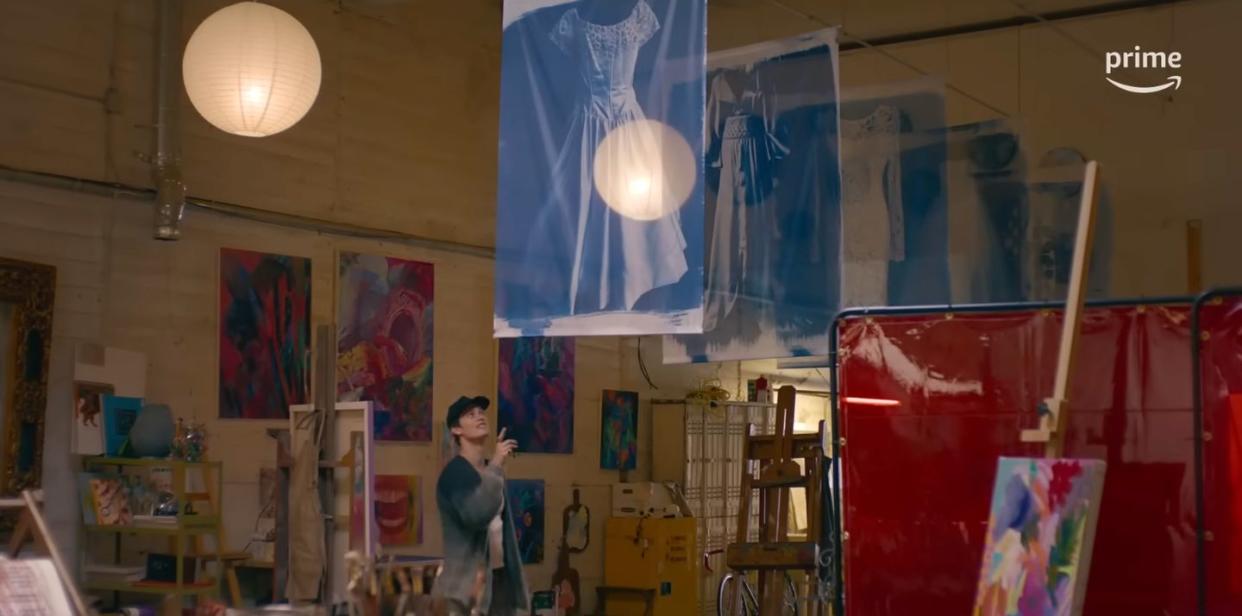 a person standing in a room with art on the wall