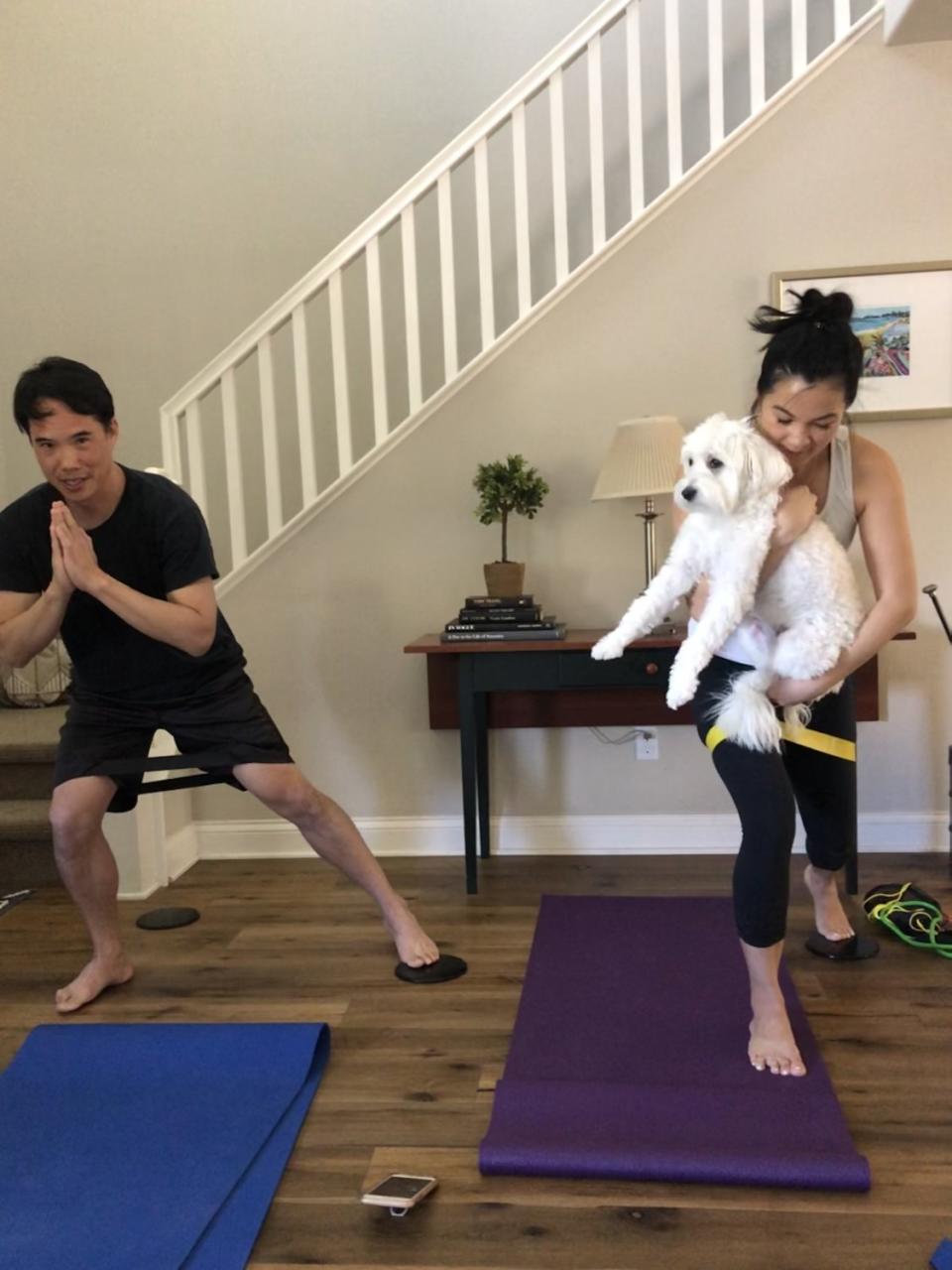 Charles Yu exercising with his wife, Michelle, and their dog.