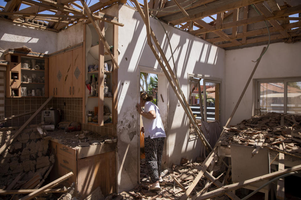 A woman surveys her damaged home after it was struck by a rocket fired from the Gaza Strip, in Sderot, May 15, 2021. No place in Israel has been hit harder by Palestinian rocket fire than Sderot, a working-class town just about a mile (1.5 kilometers) from the Gaza border. Although Sderot is enjoying an economic boom and revival, a generation of children and parents are suffering from the traumatic effects of two decades of rocket fire that experts are still struggling to understand.