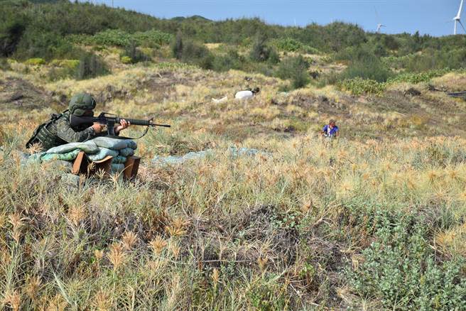 國軍漢光、同心演習28日上午在後龍鎮福寧安檢所前舉行紅、藍軍守備攻防演練，當地居民多年未見軍人出現，好奇張望。（謝明俊攝）