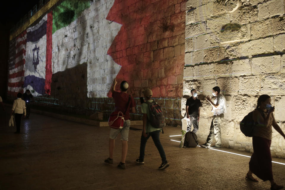 Representations of the U.S., Israeli, Emirati and Bahraini flags are projected onto a wall of Jerusalem's Old City, marking the day of a signing ceremony in Washington signifying the two Gulf nations' normalization of relations with Israel, Tuesday, Sept. 15, 2020. (AP Photo/Maya Alleruzzo)