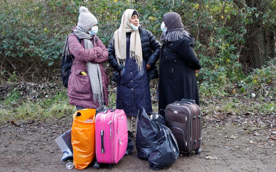 Migrant women with their belongings at a makeshift camp near Calais on Thursday