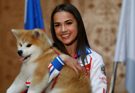 Russian figure skating gold medallist Alina Zagitova poses with an Akita Inu puppy presented to her in Moscow, Russia May 26, 2018. REUTERS/Maxim Shemetov