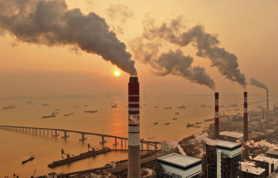 The sun sets near a coal-fired power plant on the Yangtze River in Nantong in eastern China's Jiangsu province on Dec. 12, 2018. Chinese power companies bid for credits to emit carbon dioxide and other climate-changing gases as trading on the first national carbon exchange began Friday, July 16, 2021 in a step meant to help curb worsening pollution. (Chinatopix via AP)
