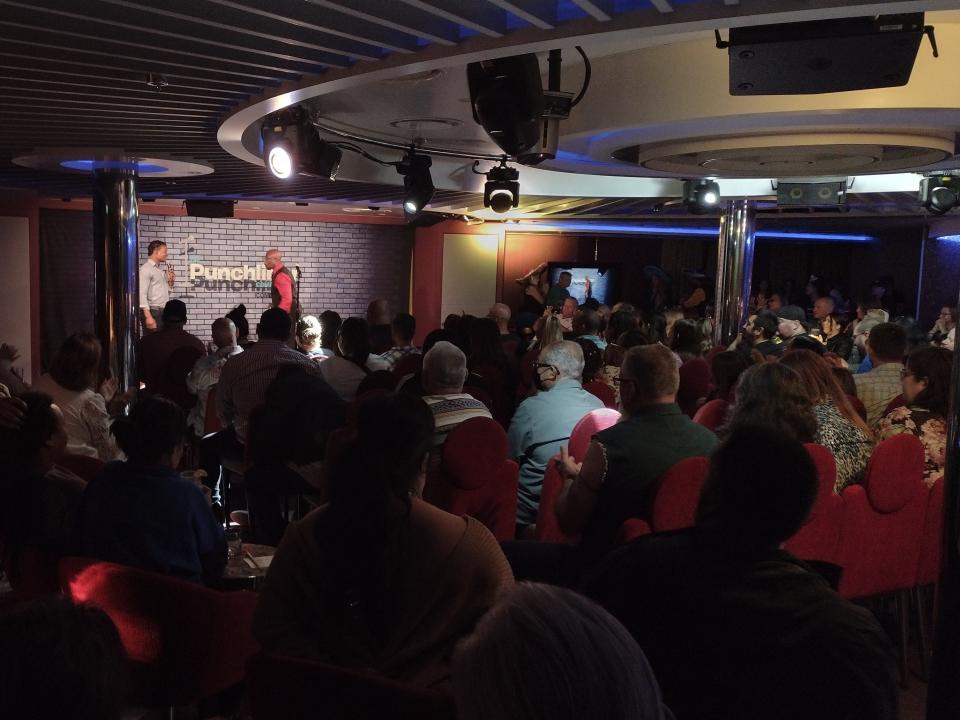 Interior shot of crowded comedy club room on Carnival Radiance cruise ship