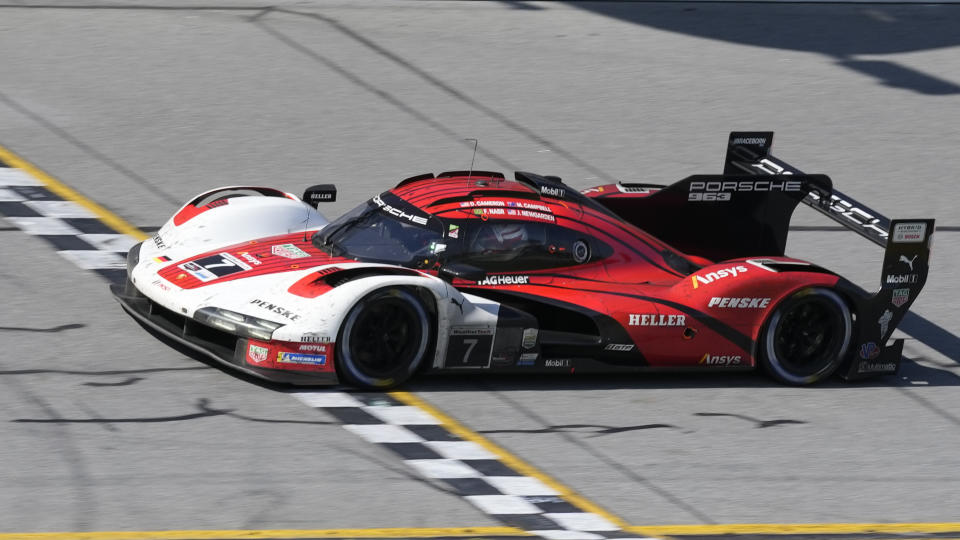 Filipe Nasr crosses the finish line in a Porsche 963 for the Porsche Penske Motorsport team to win the Rolex 24 hour auto race at Daytona International Speedway, Sunday, Jan. 28, 2024, in Daytona Beach, Fla. (AP Photo/John Raoux)