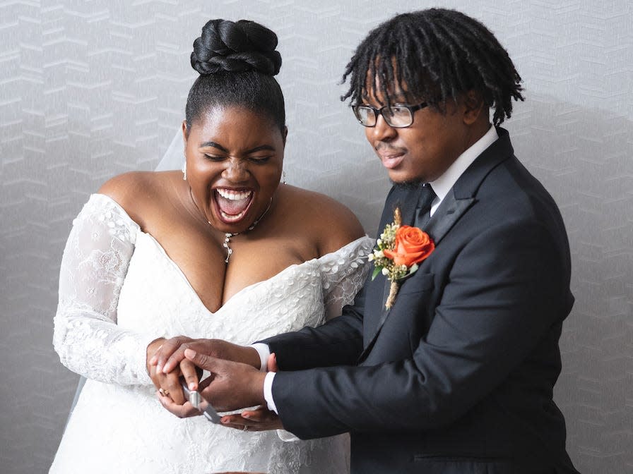 Terryn Witherspoon-Woolfolk and her husband cutting a cake on their wedding day