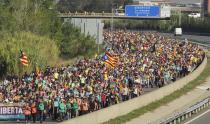 Demonstrators walk along a highway in Girona, Spain, Wednesday, Oct. 16, 2019. Thousands of people have joined five large protest marches across Catalonia that are set to converge on Barcelona, as the restive region reels from two straight days of violent clashes between police and protesters. The marches set off from several Catalan towns and aimed to reach the Catalan capital by Friday. (AP Photo/Mar Grau)