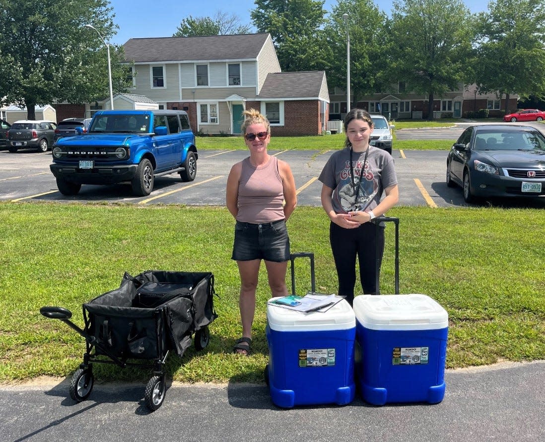 Sherisse Salter (left) and Angalena Negron distribute meals at Elmwood Gardens in Manchester with New Hampshire Hunger Solutions. They worked to expand participation in summer meals sites in the city.