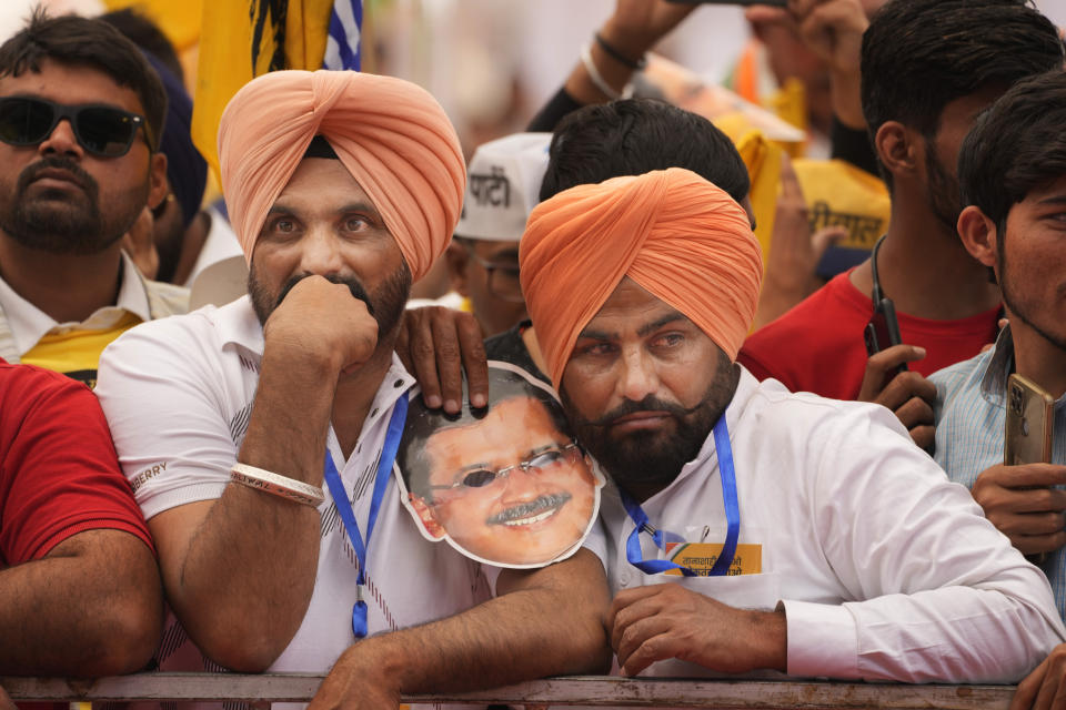 Supporters of Aam Admi Party hold a mask in the likeness of the party leader and Delhi Chief Minister Arvind Kejriwal, listen to a speaker during the 'Save Democracy' rally organized by INDIA bloc, a group formed by opposition parties, in New Delhi, India, Sunday, March 31, 2024. The "Save Democracy" rally was the first major public demonstration by the opposition bloc INDIA against the arrest of New Delhi's top elected official and opposition leader Arvind Kejriwal on March 21, in a liquor bribery case. (AP Photo/Manish Swarup)