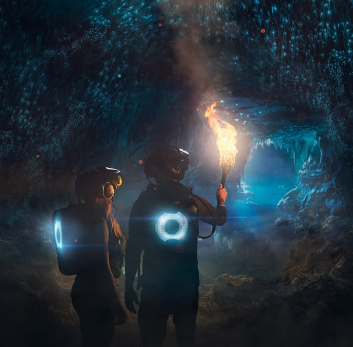 Two people in VR headsets inside a virtual cave created by The Void's VR equipment.