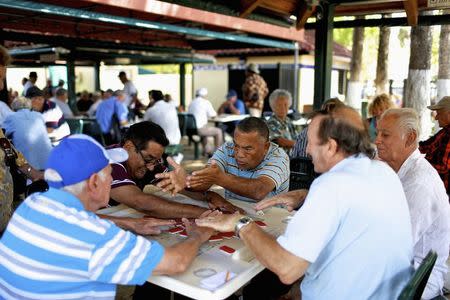 Local residents gather to play dominos at Maximo Gomez Park in the Little Havana district of Miami, Florida May 17, 2014. REUTERS/Brian Blanco