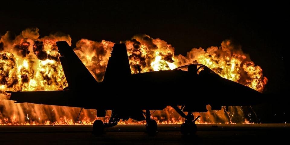 A Blue Angels aircraft is silhouetted by the "Wall of Fire" during the Marine Corps Air Station, Cherry Point, Air Show, May 4, 2018.