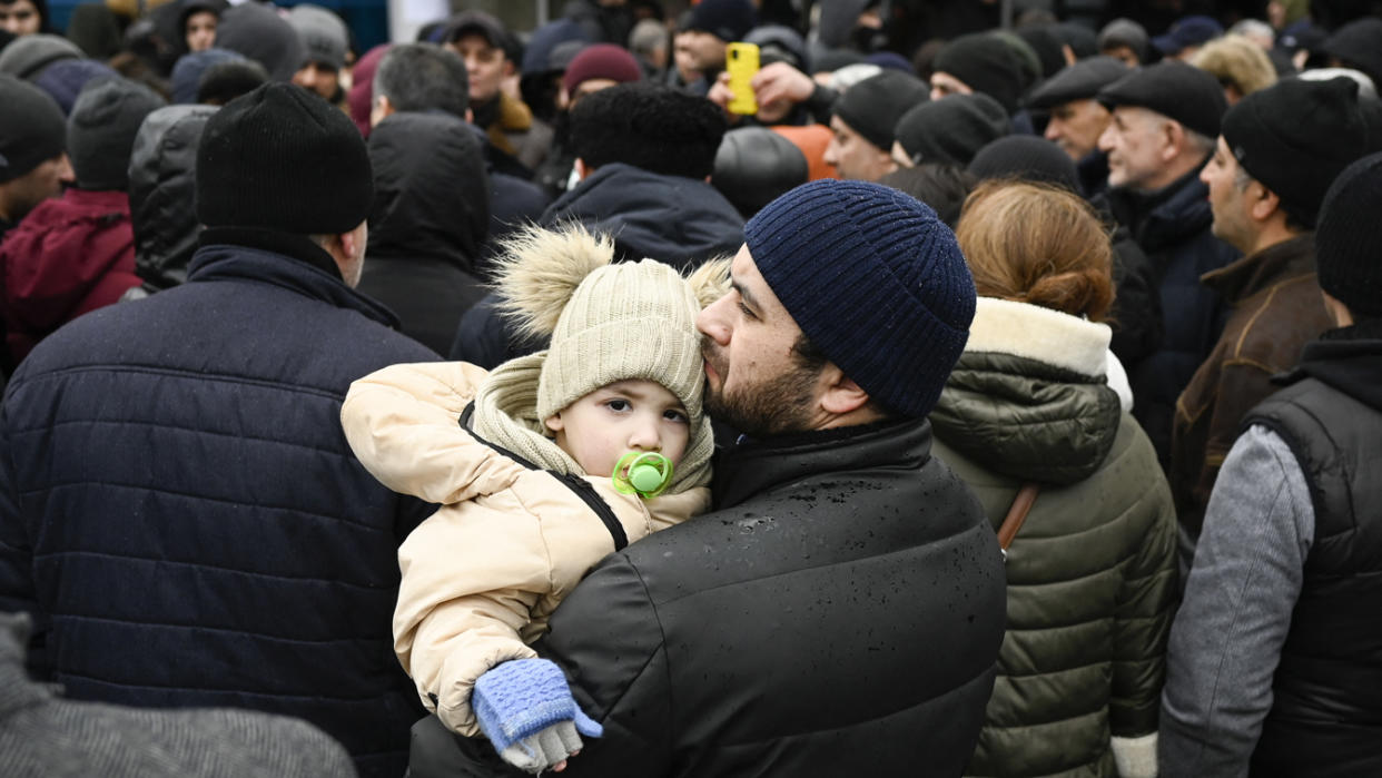 A Ukrainian refugee holds his child