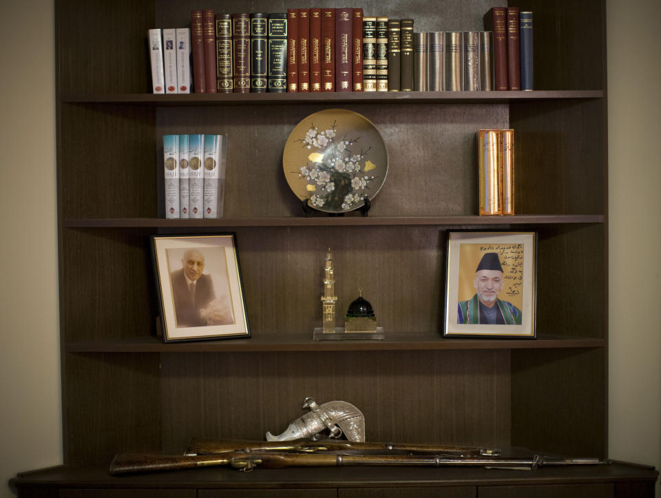 In this Thursday, March 27, 2014 photo, a picture of Afghan President Hamid Karzai is displayed on the book shelf in the living room of presidential candidate Zalmai Rassoul in Kabul, Afghanistan. Afghans go to the polls April 5, 2014 to choose a new president, and that in itself may one day be considered Karzai’s greatest achievement. (AP Photo/Anja Niedringhaus)