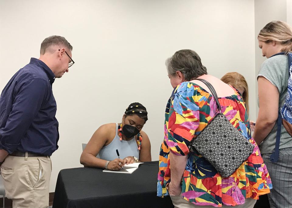 Ashley Jones, poet laureate of Alabama, signs copies of her works on Wednesday during a midday gathering at Gadsden State Community College.