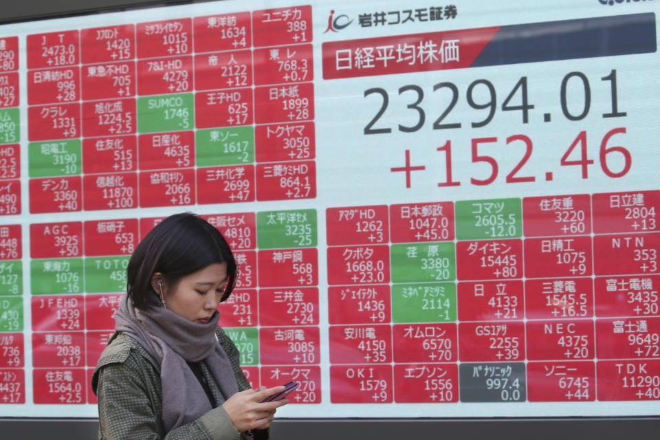 A woman walks by an electronic stock board of a securities firm in Tokyo, Friday, Nov. 15, 2019. Shares are higher in Asia after U.S. officials said China and the U.S. were getting close to an agreement to cool tensions over trade.(AP Photo/Koji Sasahara)