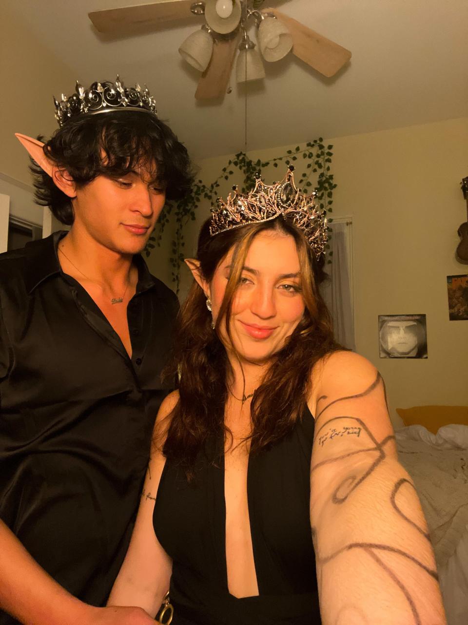 A man and woman with pointed ears and crowns pose for a selfie.