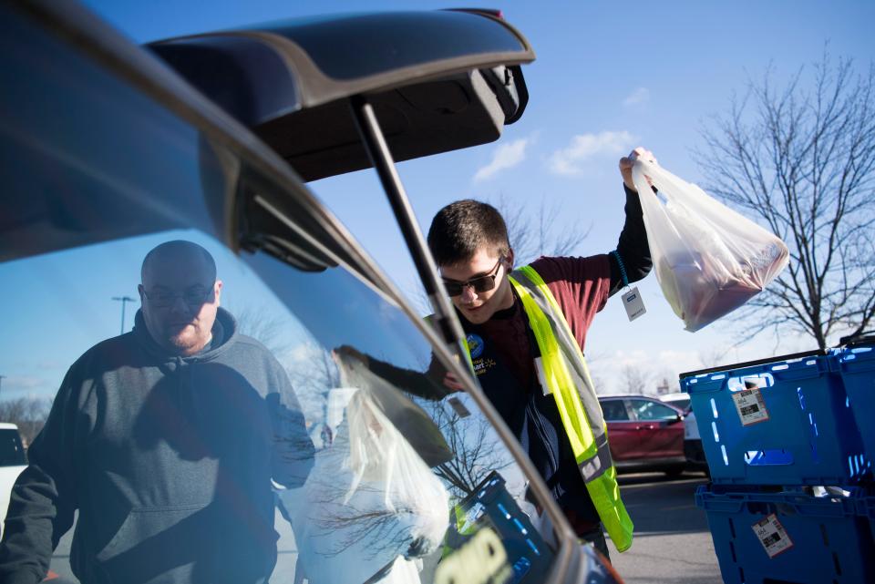 Employee Zachary Bennett assists customer Eric Knighton with his grocery pickup at the Walmart in Turkey Creek on Friday, Jan. 25, 2019.