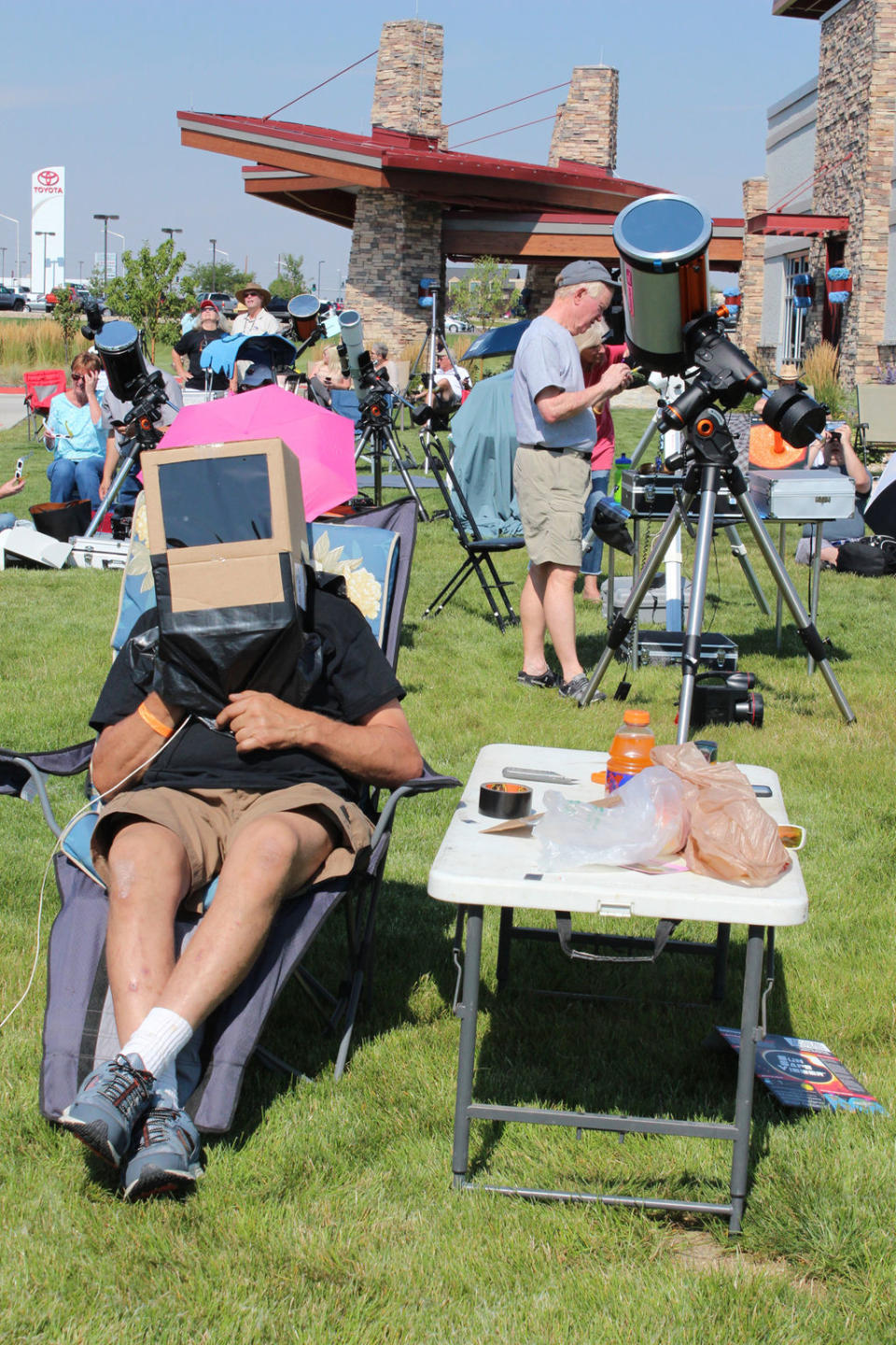 Unidentified "box boy" is ready for eclipse action at one of the total solar eclipse viewing sites in Casper, Wyoming. This observer donned a cardboard box with eye-protective plastic to view the partial eclipse before totality. <cite>Barbara David</cite>