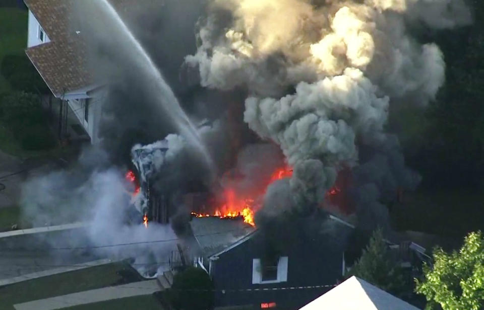 FILE - In this Sept. 13, 2018 file image take from video provided by WCVB in Boston, flames consume the roof of a home following an explosion in Lawrence, Mass, a suburb of Boston. Federal investigators are confirming that over pressurized natural gas lines were the source of a series of explosions and fires in communities north of Boston last month. The preliminary report on Thursday, Oct. 11 from the National Transportation Safety Board said that Columbia Gas work in Lawrence on Sept. 13 failed to account for the location of critical gas pressure sensors, causing high-pressure gas to flood the distribution system at excessive levels. (WCVB via AP, File)