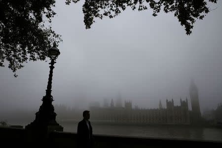 A man walks past the Big Ben clocktower and the Houses of Parliament during a foggy day in central London, November 2, 2015. REUTERS/Stefan Wermuth