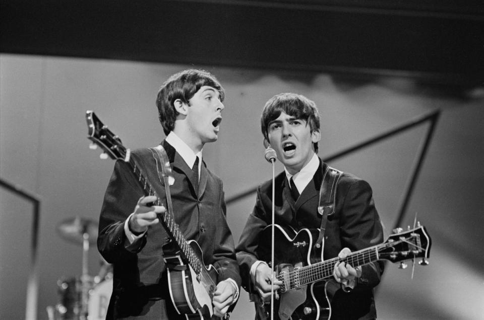 Paul McCartney and George Harrison on stage at the London Palladium on 13 October 1963 (Getty)