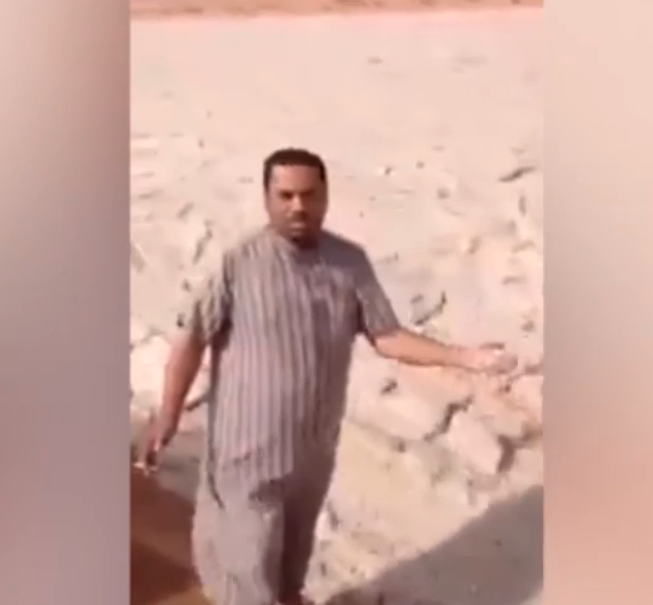 A Saudi Arabian man can be seen picking up a handful of hail in unprecedented weather conditions. Photo: LiveLeak