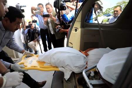 Workers place the body of Valeria, daughter of Oscar Alberto Martinez Ramirez, migrants who drowned in the Rio Grande river during their journey to the U.S., inside a hearse in Matamoros