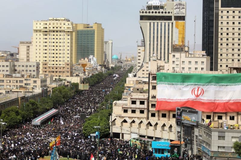 Mourners attend the funeral ceremony in the city of Mashhad for Iran's late President Ebrahim Raisi, Foreign Minister Hossein Amir-Abdollahian and others who were killed in a helicopter crash on Sunday. -/Iranian Presidency/dpa