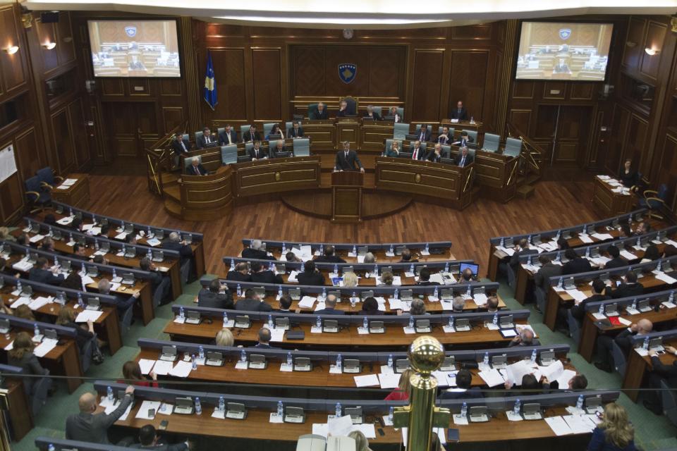 Kosovo Prime Minister Hashim Thaci, standing centre, opens a session in Kosovo's parliament in the capital Pristina on Wednesday April 23, 2014. Kosovo's parliament voted Wednesday on a law that will enable the creation of a special war crimes tribunal staffed by international judges and prosecutors that will try alleged crimes committed by former ethnic Albanian rebels during Kosovo's 1998-99 war for independence from Serbia. (AP Photo/Visar Kryeziu)