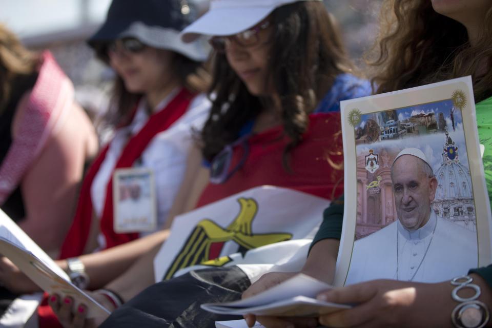 A faithful holds a picture of Pope Francis as he celebrates a mass in Amman's International Stadium